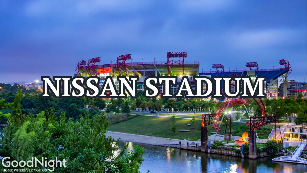 A panoramic view of Nissan Stadium along the riverfront, framed by green space and a pedestrian bridge. The scene conveys the excitement of attending a major sports event while also showing the proximity to outdoor urban attractions and group-friendly activities.
